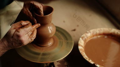陶艺家生产粘土Jar陶器未被认可的男人。工作湿粘土